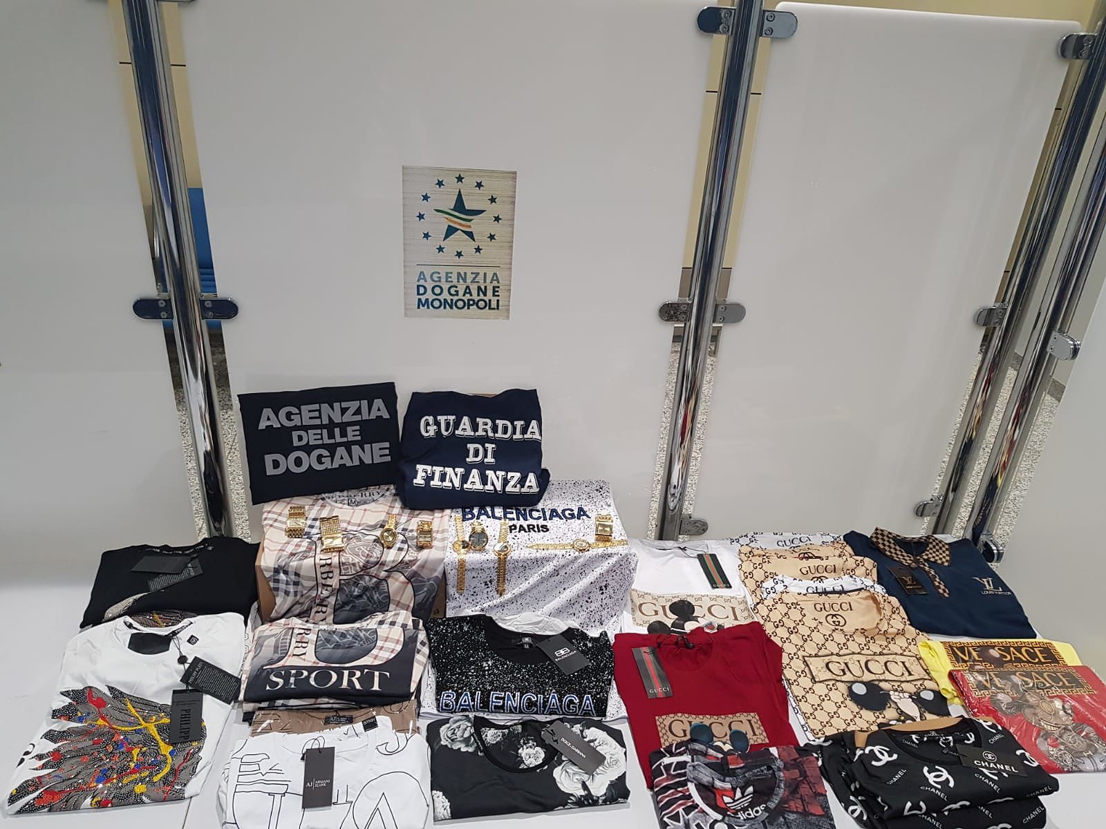 Maglie e orologi contraffatti in valigia, maxi sequestro a Elmas: denunciata una donna