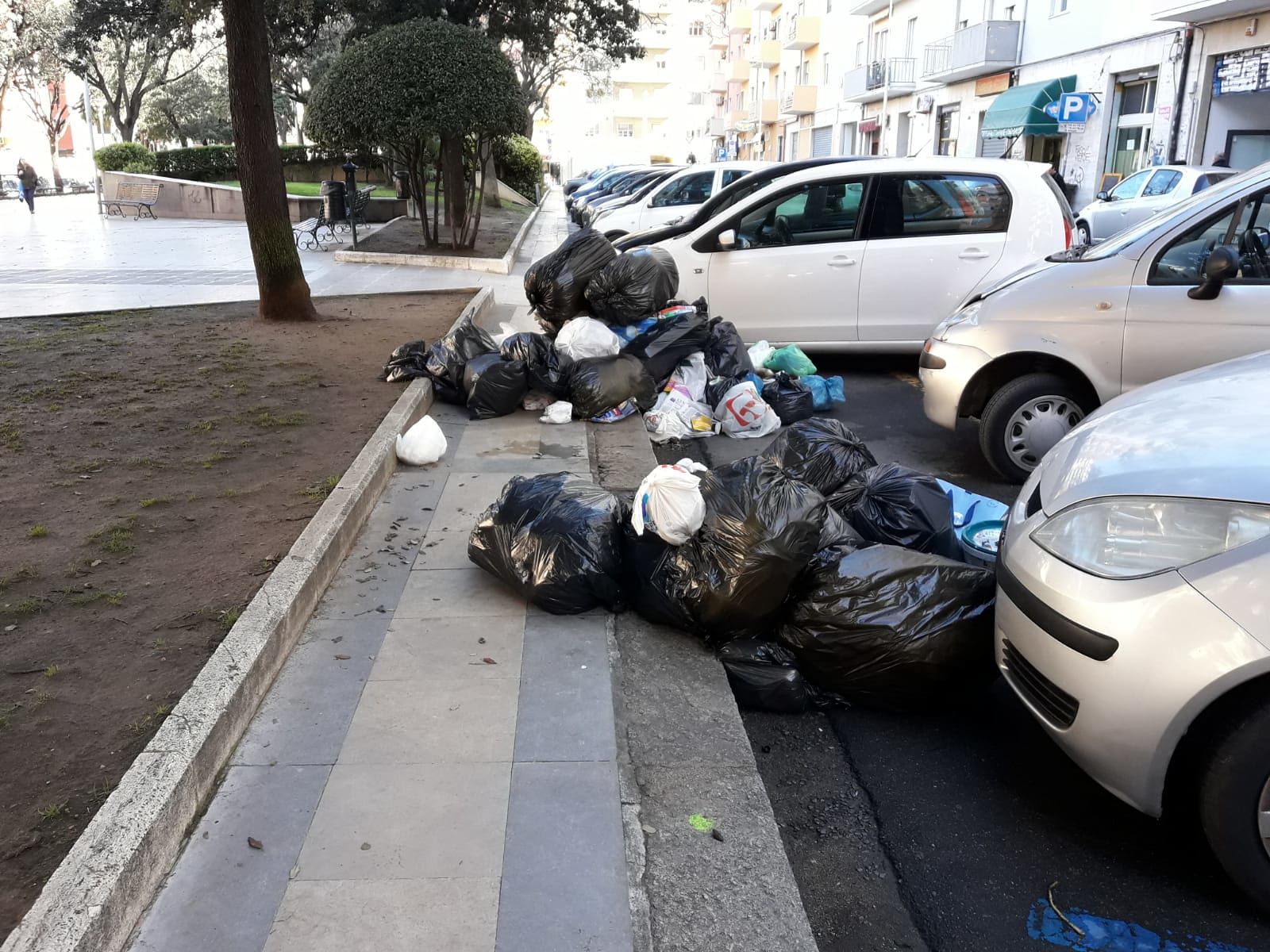 Cagliari, in piazza Michelangelo rifiuti ammassati in strada: trionfano puzza e liquami