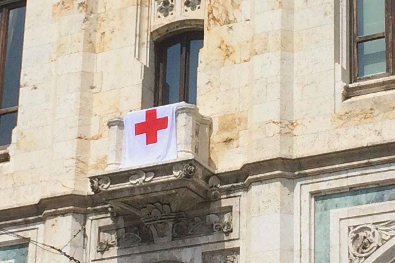 Esposta sulla facciata del Municipio la bandiera della Croce Rossa a Cagliari