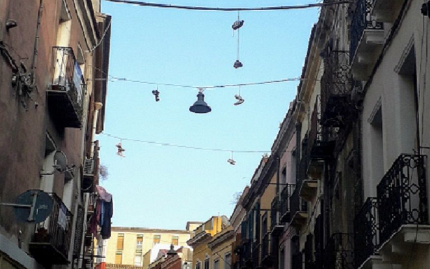 Cagliari, la nuova “moda” nel Corso: scarpe appese ai cavi dell’elettricità