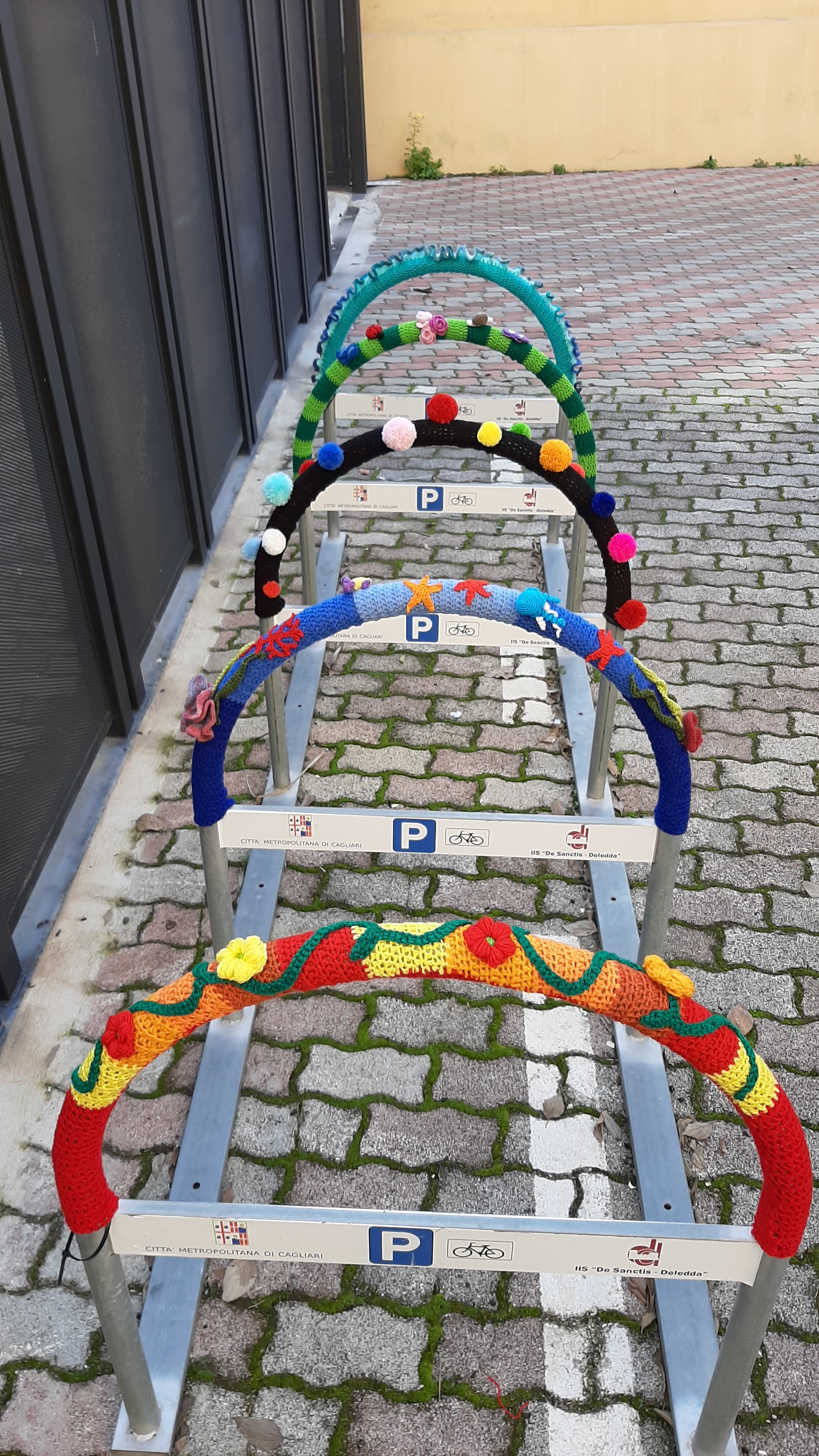 Bombardamento (di fili di lana)il parcheggio bici all’Ex-Manifattura di Cagliari: le rastrelliere colorate