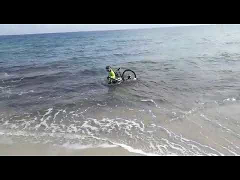 Covid-19, ciclista entra in mare con la sua bici per cercare di evitare il controllo: “Dai, venite, uscite….” (VIDEO)