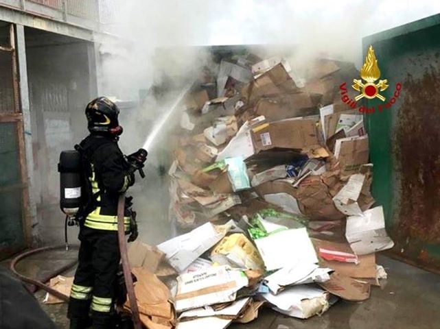 Carbonia, compattatore del cartone in fiamme davanti a un supermercato: vigili del fuoco in azione