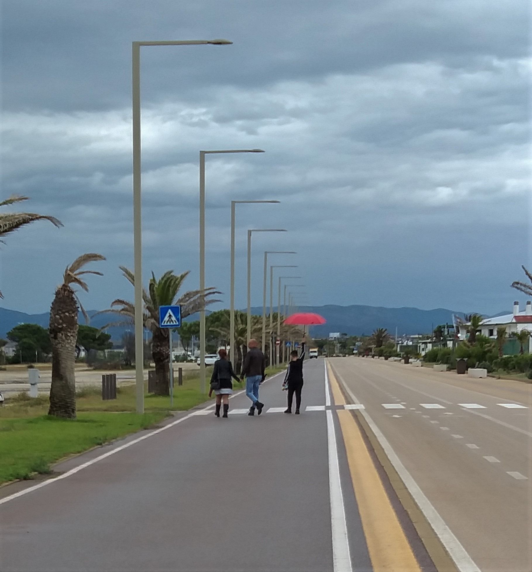 Cagliari, il bimbo con l’ombrello rosso nel Poetto piovoso: “Tanto domani c’è sempre il sole”