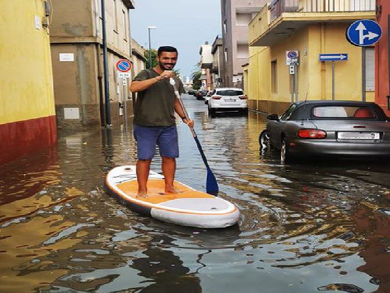 Selargius, in giro col sup nelle strade invase dall’acqua: “Vado a fare la spesa”