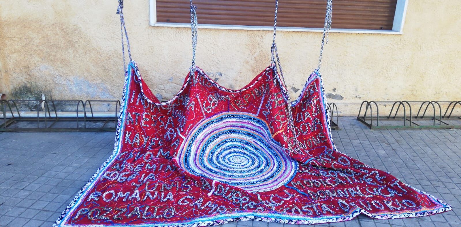 Officin&Ideali, da stamattina a San Sperate sono esposti l’arazzo e la bandiera dell’atelier artistico di Jonida Xheri