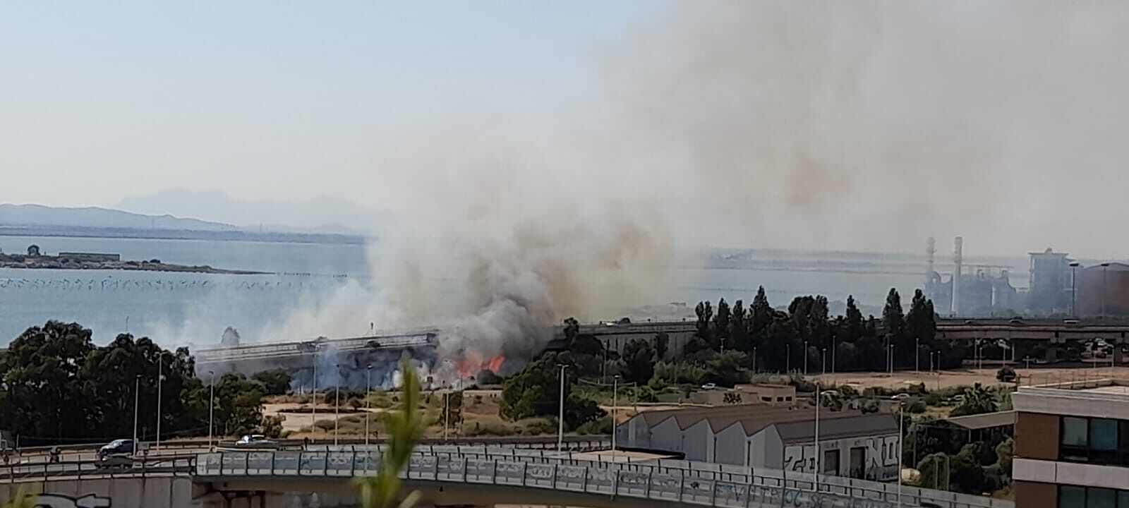Cagliari, fiamme alte e tanto fumo a Santa Gilla: incendio vicino alla Statale