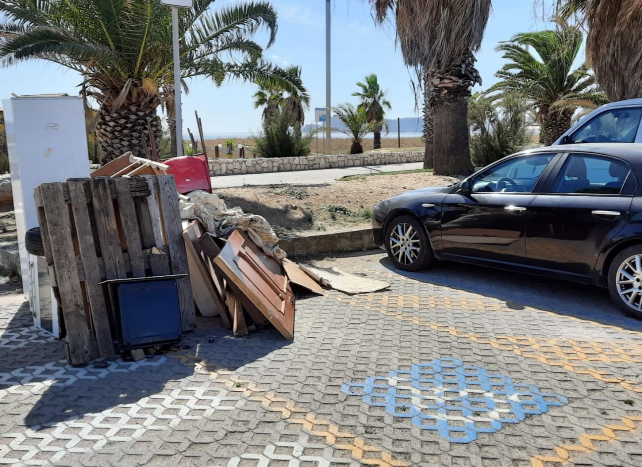 La grande vergogna al Poetto di Quartu, porte e sedie vecchie ammassate sopra il parcheggio per disabili