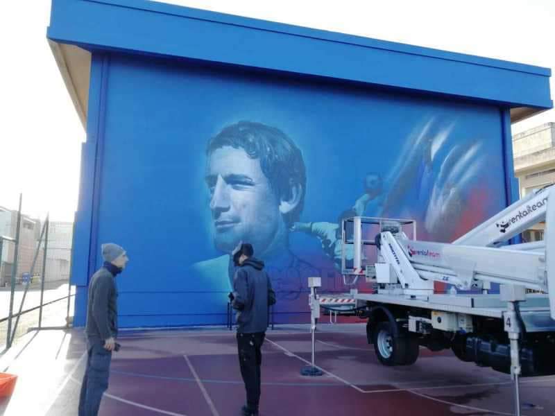 Maxi murale di Gigi Riva a Quartucciu, il volto del mito rossoblù sulla facciata della scuola