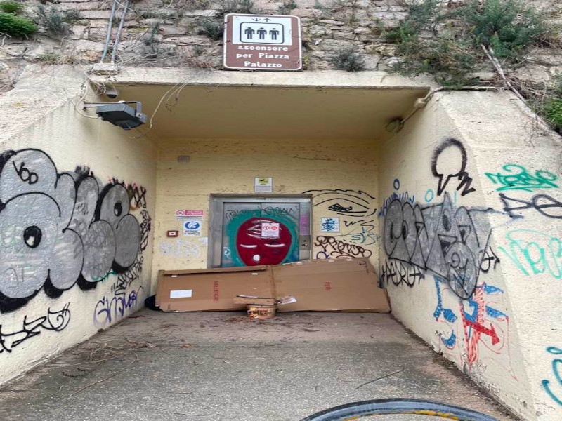 Cagliari, degrado senza fine in centro: davanti all’ascensore ko un rifugio per senzatetto