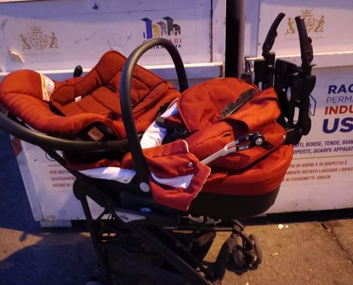 Pirri, un kit porta enfant accanto al raccoglitore di indumenti usati