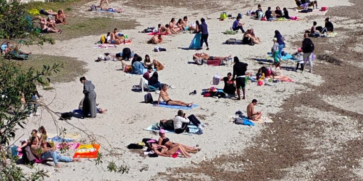 Cagliari, quanta voglia di primavera e di mare: la spiaggia di Calamosca invasa dai bagnanti