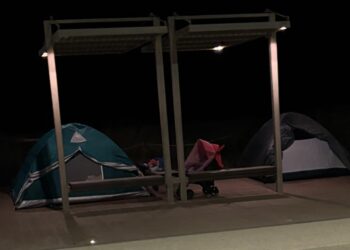 Poetto, incredibile campeggio improvvisato sul lungomare: le tende piazzate sotto le pensiline come in un’area attrezzata