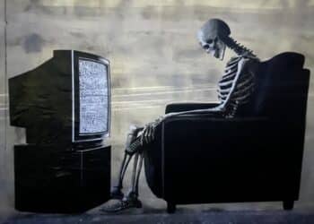 Cagliari, tanta curiosità per lo strano murale a Bonaria: lo scheletro davanti alla tv