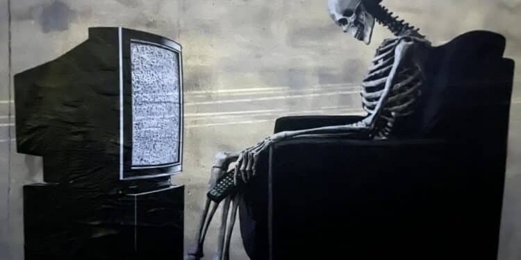 Cagliari, tanta curiosità per lo strano murale a Bonaria: lo scheletro davanti alla tv