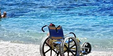 In carrozzina fino al mare, poi il bagno tra le onde: il sorriso della libertà commuove una spiaggia