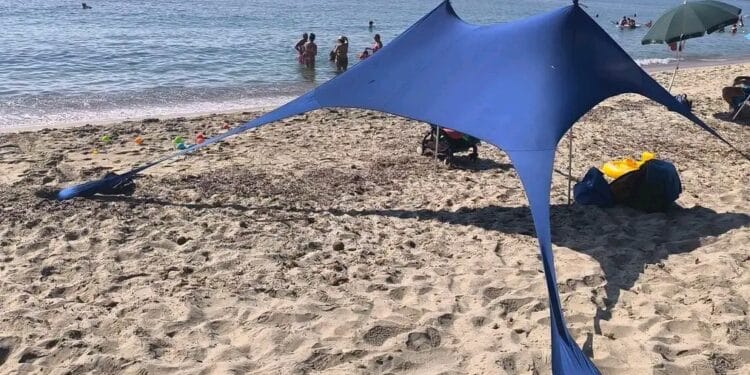 Nora, il maxi telo in spiaggia divide i bagnanti: “Sono accampamenti abusivi”. Ma c’è chi replica: “Lasciateci vivere il mare in libertà”